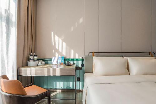 a bedroom with two beds and a desk and a chair at Atour Light Hotel Shanghai Jing'an Natural History Museum, Suzhou River Bank in Shanghai