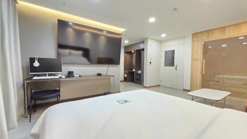 アンソンにあるRoad35 Hotelの白いベッドと机があるホテルの部屋
