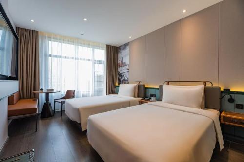 a hotel room with two beds and a table at Atour Light Hotel Shanghai Jing'an Natural History Museum, Suzhou River Bank in Shanghai
