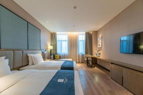 Ένα ή περισσότερα κρεβάτια σε δωμάτιο στο Echarm Hotel Jinan Railway Station Daming Lake