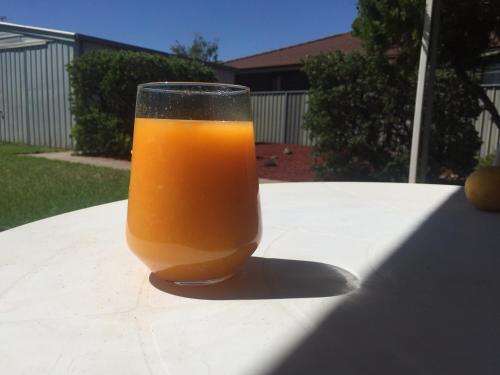 a glass of orange juice sitting on a table at Quiet court easy stroll shops 500 metres from Centro in Mildura