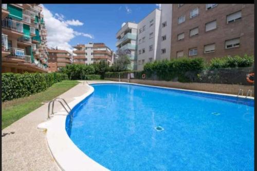 een groot blauw zwembad voor sommige gebouwen bij Piso Salou in Salou