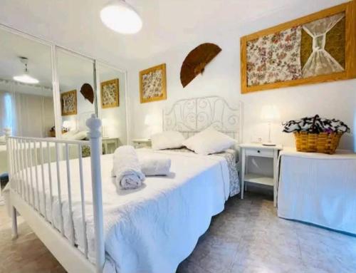 een slaapkamer met een wit bed en een bureau bij Piso Salou in Salou