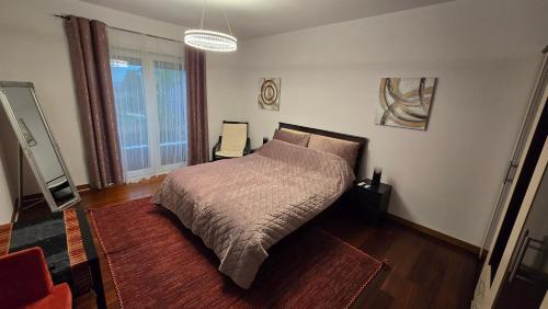 a bedroom with a bed and a large window at AVS Concept Cosmopolis in Ştefăneştii de Sus