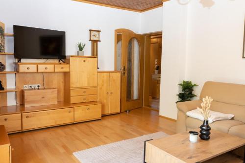 a living room with a tv and a couch and a table at Landhaus Fliederweg in Völkermarkt