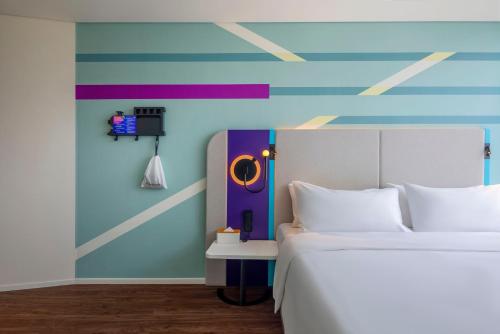a bedroom with a bed and a colorful wall at Tru by Hilton Bac Giang City Centre in Bắc Giang