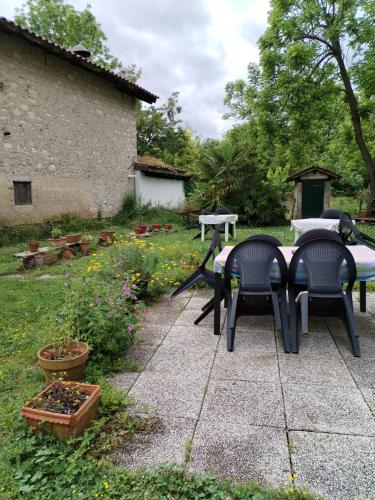 a patio with two chairs and a table in a garden at Stasion Di Pueste in Nogaredo Al Torre