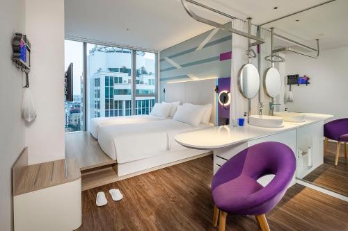 Bắc GiangTru by Hilton Bac Giang City Centre的酒店客房,配有一张床和一张紫色椅子