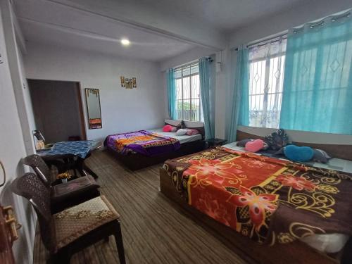 una habitación de hotel con dos camas y una silla en Arwah Scenic view homestay, en Cherrapunji