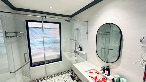 un bagno con doccia, lavandino e specchio di LuangPrabang Orient Boutique Hotel a Luang Prabang