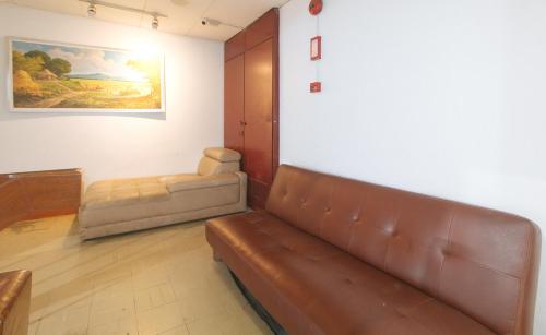 a living room with a couch and a chair at Stay Malate Hostel by RedDoorz in Manila