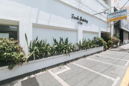 a building with plants on the side of it at Stay Malate Hostel by RedDoorz in Manila