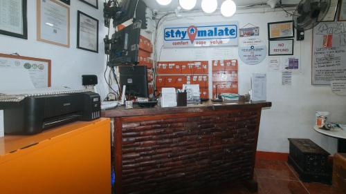 a bar in a restaurant with a brick wall at Stay Malate Hostel by RedDoorz in Manila