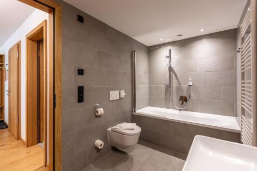 a bathroom with a tub and a toilet and a sink at keyone homes Zwieselstein in Sölden