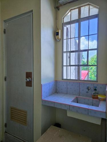 a bathroom with a sink and a window at Happy Homes Guest House in Legazpi