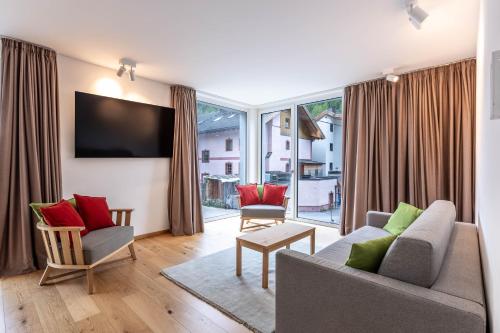 a living room with a couch and chairs and a tv at keyone homes Zwieselstein in Sölden