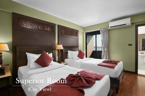 a hotel room with two beds and a window at Baan Wanglang Riverside, Bangkok in Bangkok