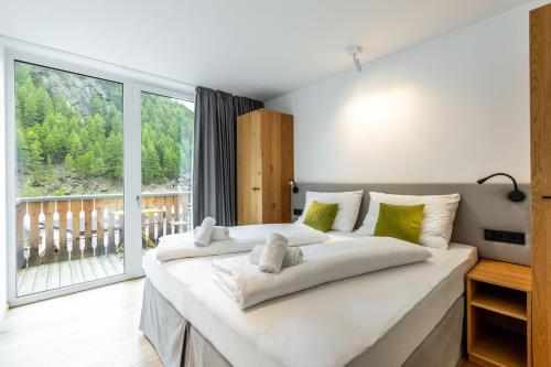a bedroom with a large bed with a large window at keyone homes Zwieselstein in Sölden