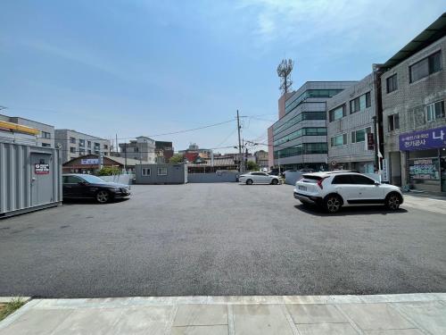 a parking lot with cars parked in a city at Road35 Hotel in Anseong