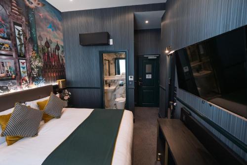 a bedroom with a large bed and a television at Hyde Park Green in London