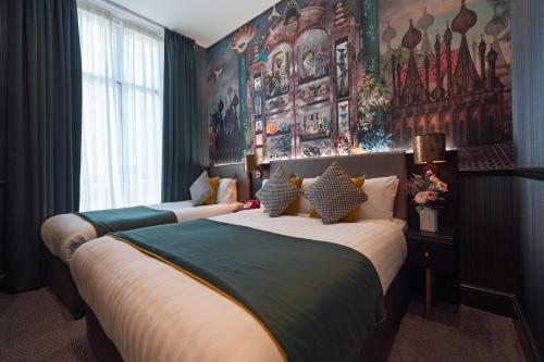 two beds in a room with paintings on the wall at Hyde Park Green in London