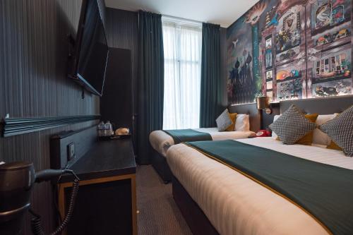 a hotel room with two beds and a tv at Hyde Park Green in London