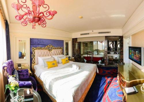a bedroom with a large bed and a chandelier at Hohhot Inner Mongolia Hotel in Hohhot