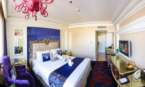 a bedroom with a large bed and a chandelier at Hohhot Inner Mongolia Hotel in Hohhot