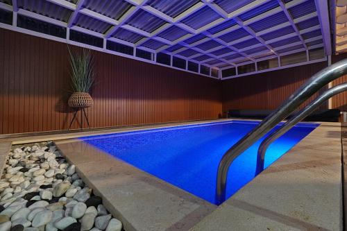a swimming pool in a house with a ceiling at בקתה בשמורה in Shomera