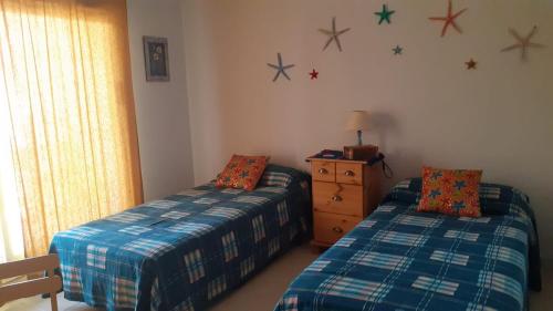 Un dormitorio con dos camas y estrellas en la pared. en Superbe appartement, en Peñíscola