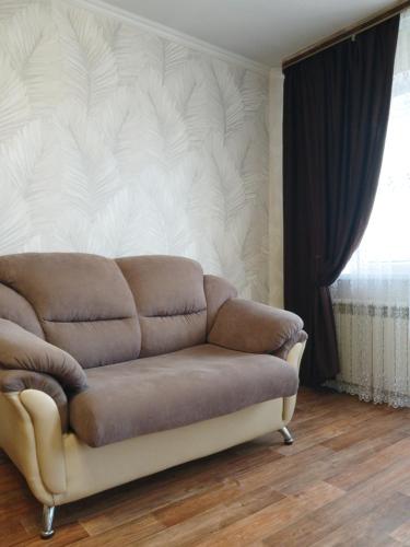 a couch in a living room with a wall at Апартаменты в центре города со смарт тв и Wi-Fi in Karagandy