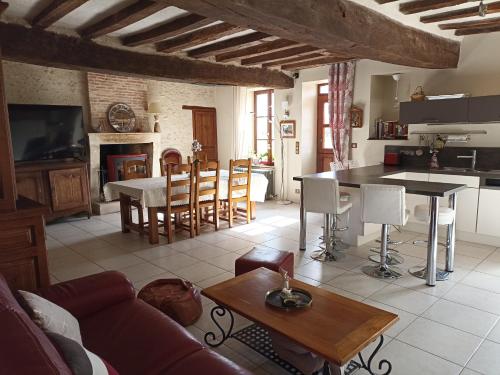 un salon avec un canapé et une table et une cuisine dans l'établissement Ferme de Mazerolles, à Saulnay