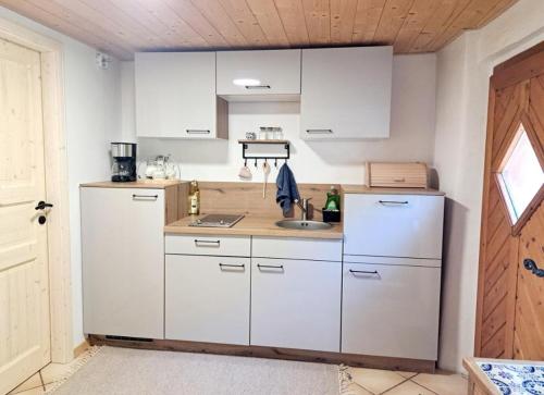 a kitchen with white cabinets and a sink at Ferienwohnung Urmannsau in Gaming