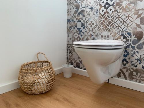 a bathroom with a toilet and a basket at Das Sommerhaus in Zülow