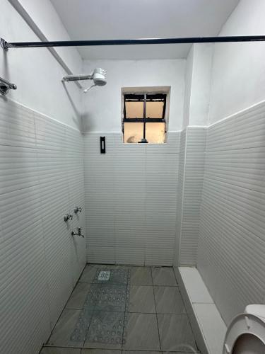 a bathroom with a toilet and a window at Pamoja stays - Modern studio near transit with balcony and workspace in Rungiri
