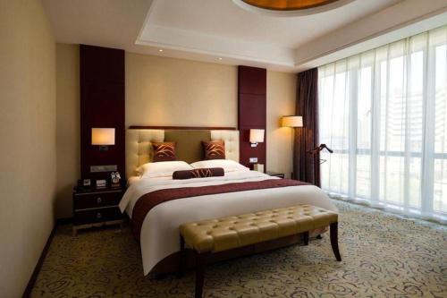 a large bedroom with a large bed and a window at Northwest Petroleum Hotel in Ürümqi