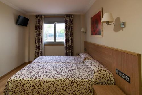 a bedroom with a bed and a window at Pontus Veteris in Sanxenxo