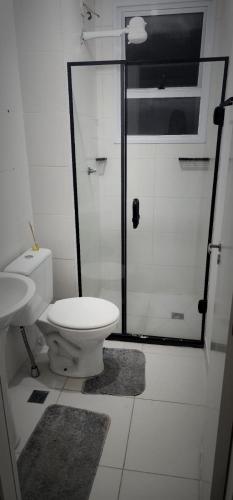 a bathroom with a toilet and a glass shower at Apto novíssimo prox Alphaville e ginásio barueri in Jandira