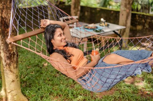 a woman laying in a hammock in a yard at Artisan By Sebu in Galle