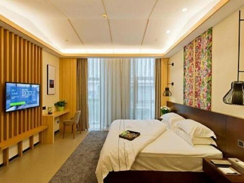 a hotel room with a large bed and a television at Musang Smart Hotel Changzhou in Changzhou