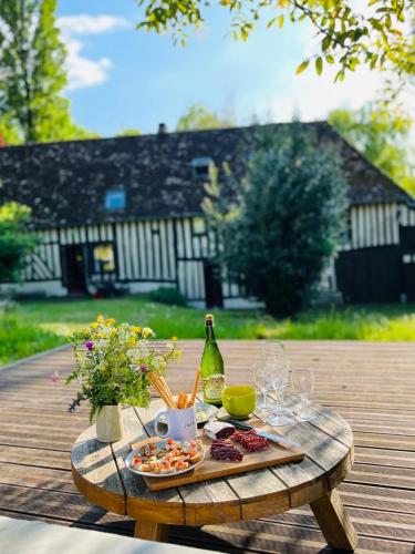 - une table avec un plateau de nourriture et une bouteille de vin dans l'établissement La maison du Cotil, à Le Renouard