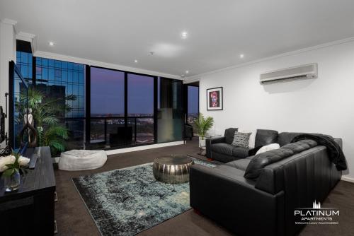 a living room with a couch and a table at Platinum Luxury Stays The Grande Large 4 BRM 3 Bath Apt in Melbourne