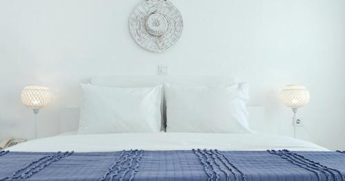 a white bed with a blue blanket and white pillows at Narges Hotel in Aliki