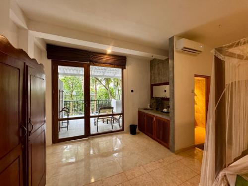 a living room with a kitchen and a balcony at Brinkhouse Guesthouse , Unawatuna beach in Unawatuna
