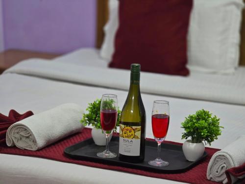 a tray with a bottle of wine and two glasses at Hotel City Gold - Hotel in Dharamshala in Dharmsala