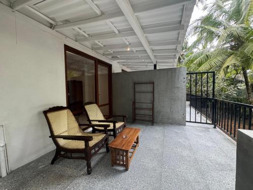 a patio with two chairs and a table on a balcony at Brinkhouse Guesthouse , Unawatuna beach in Unawatuna