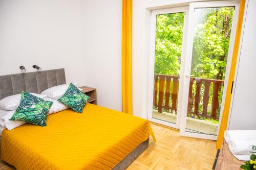 a yellow bed in a room with a window at VITA MINERALIS Szczawnica in Szczawnica
