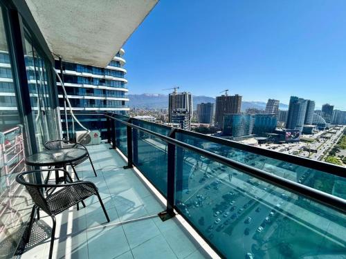 a balcony with two chairs and a view of a city at Real Beach Tower in Batumi