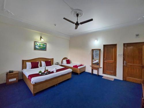 a bedroom with two beds and a ceiling fan at Hotel City Gold - Hotel in Dharamshala in Dharmsala