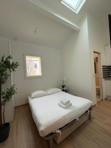 - une chambre blanche avec un lit dans l'établissement Nest by Eiffel Tower and Roland Garros, à Paris